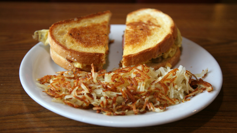 Hash browns on plate, with grilled cheese sandwich