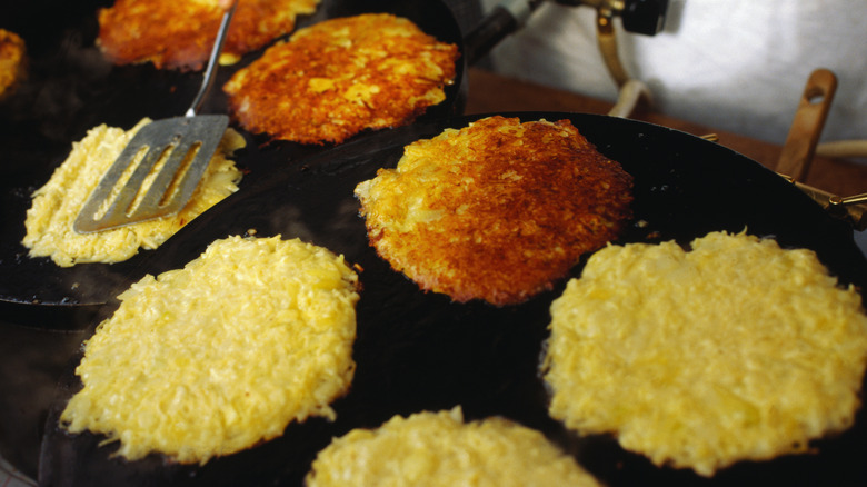 Hash browns being cooked on flat top griddle
