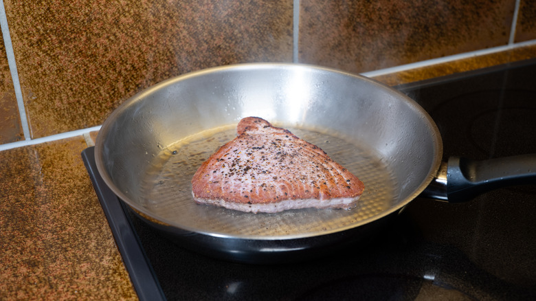 Tuna steak cooking in a sauté pan