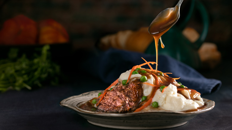 pouring gravy on pot roast