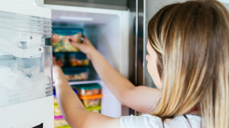 woman storing food in freezer