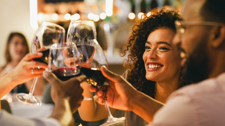 Glass and bottle of red wine, sitting on a wooden board
