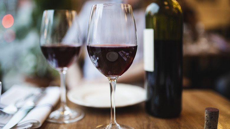 Glasses and bottle of red wine on a restaurant table