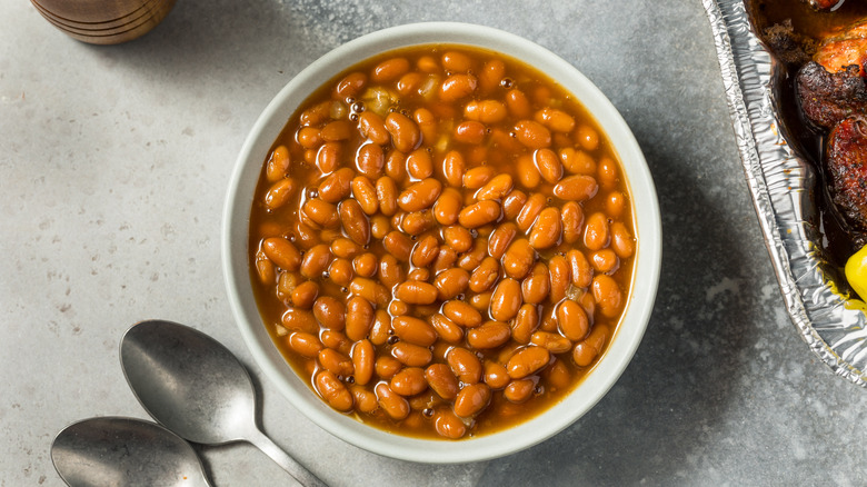 a bowl of baked beans on a slate table.