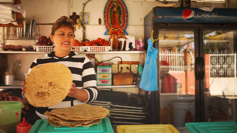 Woman cooking tlayuda in street stall
