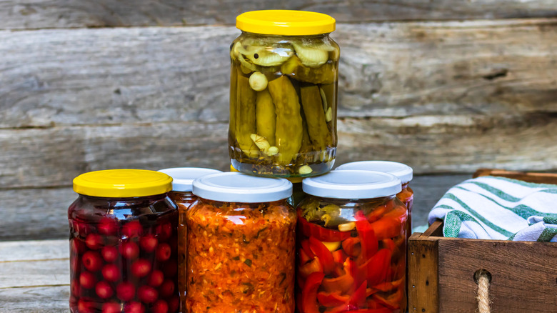 A few jars of pickled vegetables against a rustic wooden backdrop