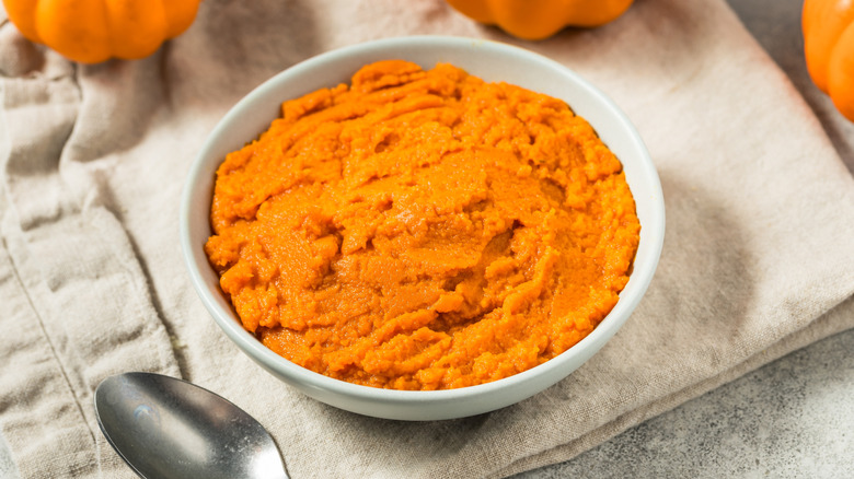 Pumpkin puree in a white bowl on a cloth