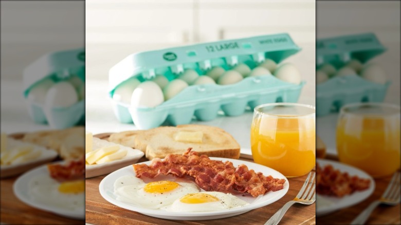 A package of Great Value eggs with a breakfast of egg and bacon on a plate