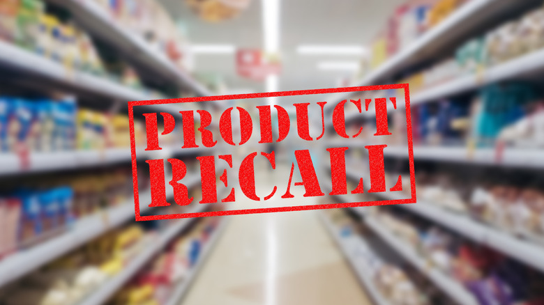 A product recall sign in front of a Walmart store aisle