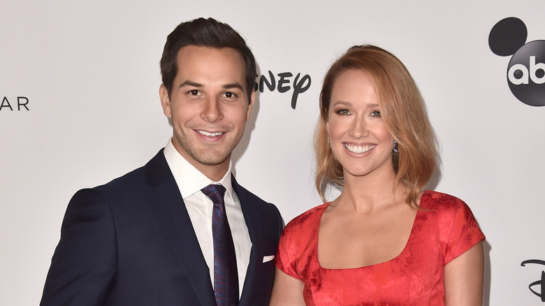 Anna Camp and Skylar Astin smile at the camera
