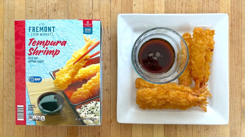 Box and white plate of Fremont Fish Market Tempura Shrimp with glass bowl of soy dipping sauce