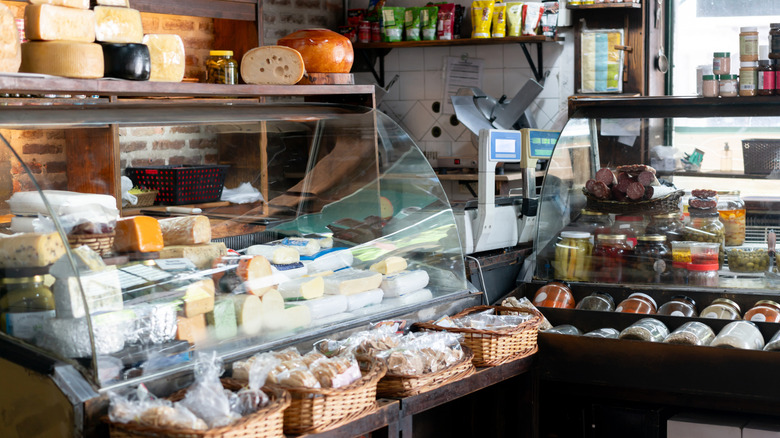Deli counter, with cheese and jars of pickled vegetables