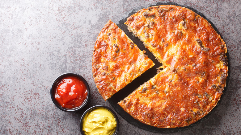 Cheeseburger pie, with tomato ketchup and mustard dips