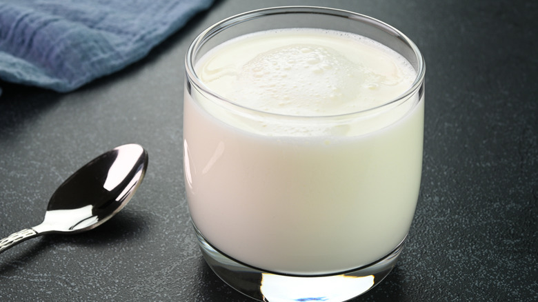 Buttermilk served in a glass cup, with a spoon sitting next to it