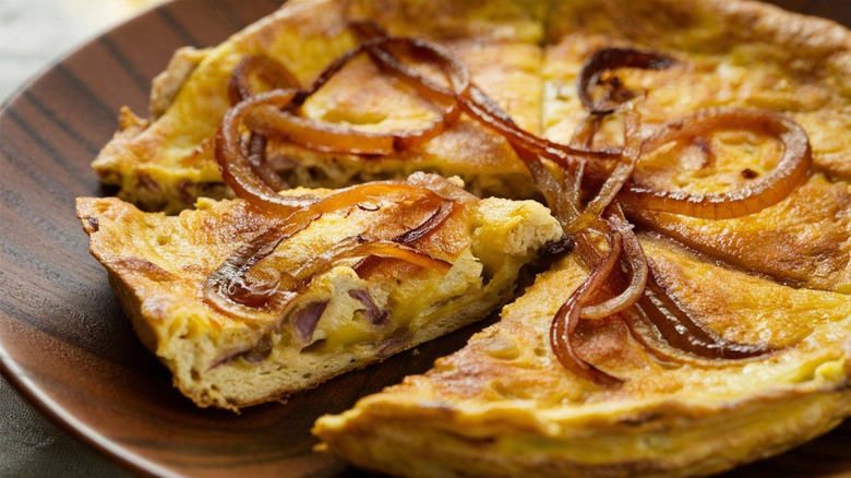 A sliced frittata topped with caramelized onions