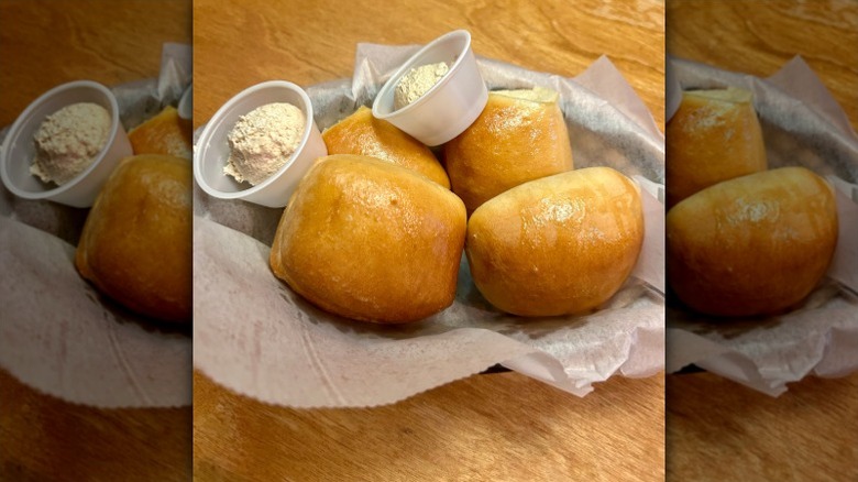 Close up of Texas Roadhouse honey cinnamon butter with some rolls in a basket