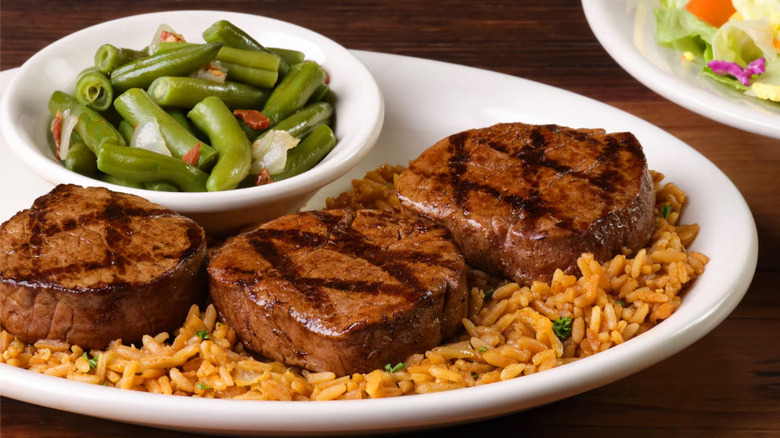 Texas Roadhouse Filet Medallions on a plate with rice and green beans