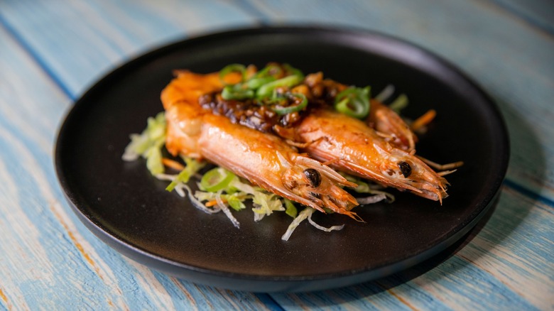two prawns on black plate