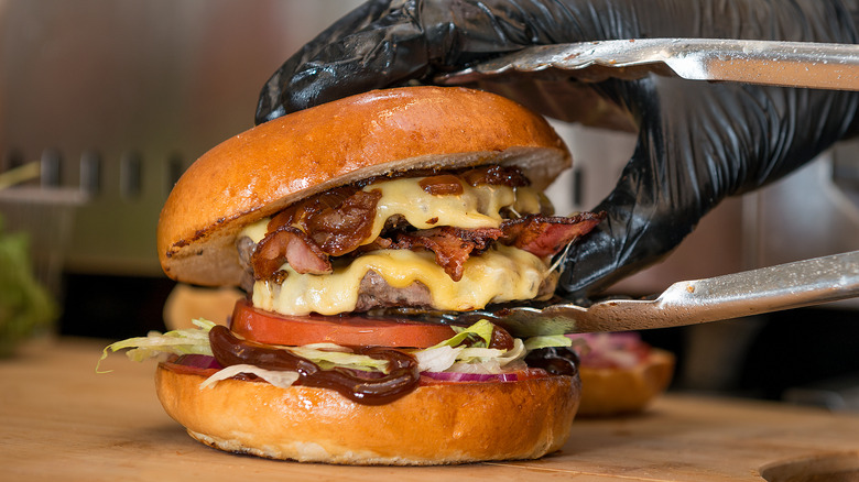 cook assembling cheeseburger