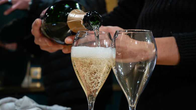 A waiter pours a glass of champagne