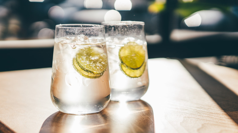 Two glasses of tonic water sit on a counter