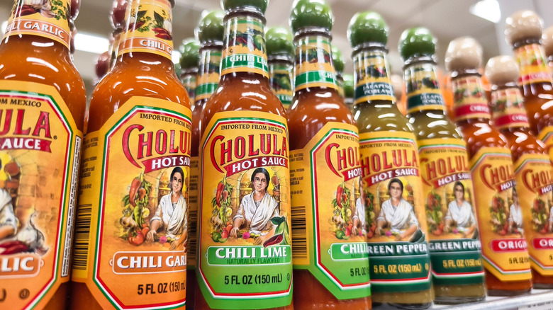 Multiple Cholula bottles on a supermarket shelf