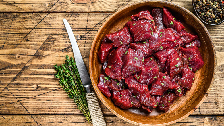 venison meat in wooden bowl