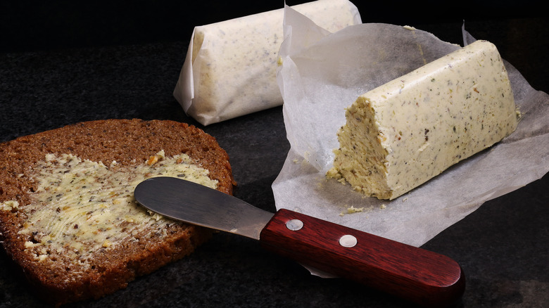 log of butter and piece of toast with spreader