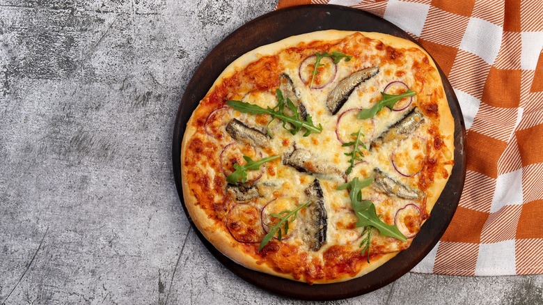 pizza with sardines on platter