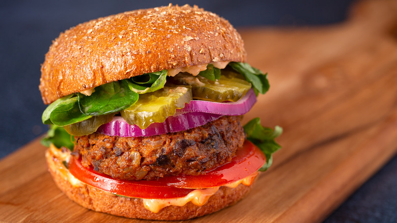 Homemade bean burger in a bun with salad and pickles