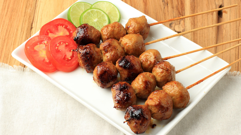 Meatball skewers on a plate with veggies
