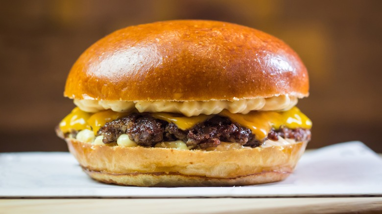 A smash burger placed on a wooden board