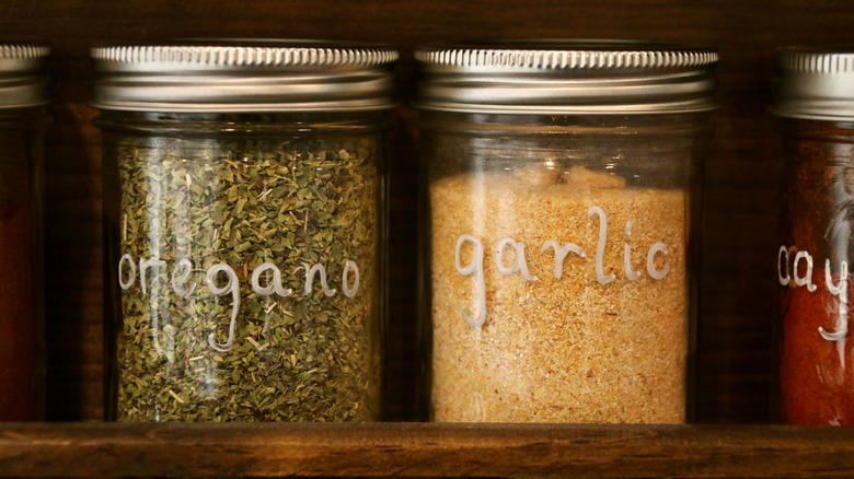 Oregano and garlic in mason jars on a spice rack