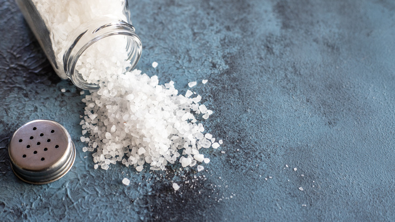 Rock salt spills from an open jar