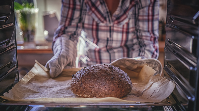 pulling fresh bread from oven