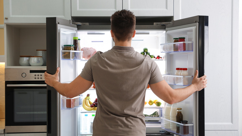 Person staring at contents of their refrigerator