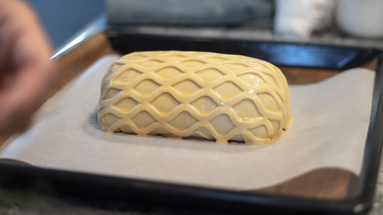 Assembled beef Wellington on baking sheet