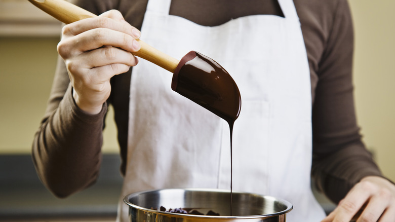 Person melting dark chocolate