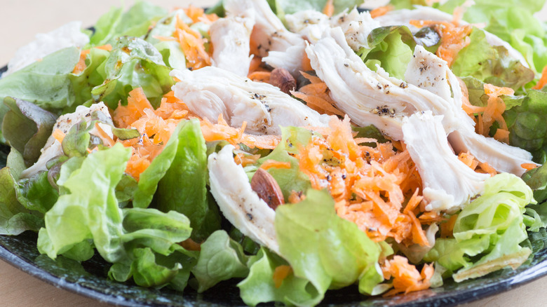 shredded chicken and carrots on lettuce
