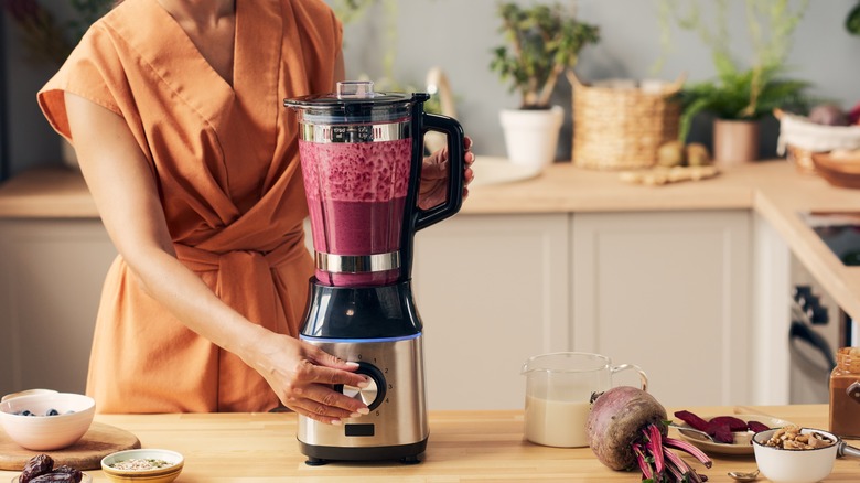 Person using blender in kitchen 