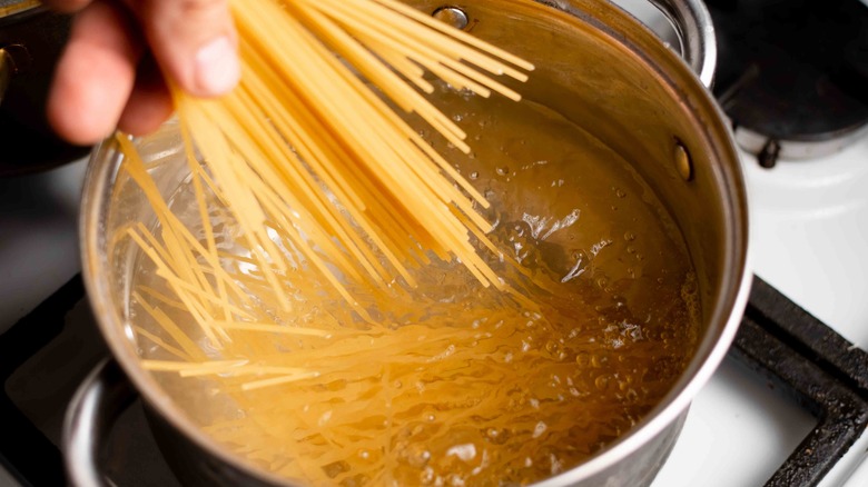 spaghetti being added to pot