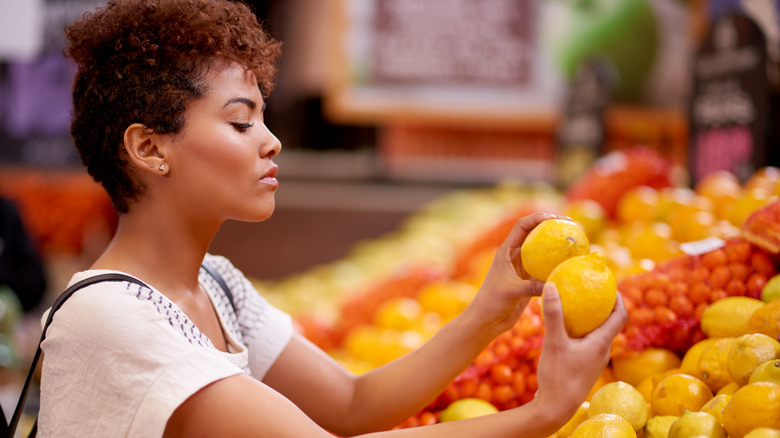 woman examining lemons