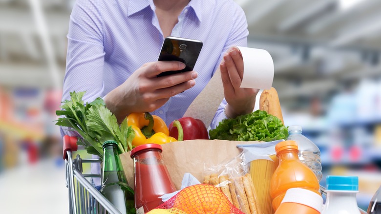 grocery shopper with phone and receipt