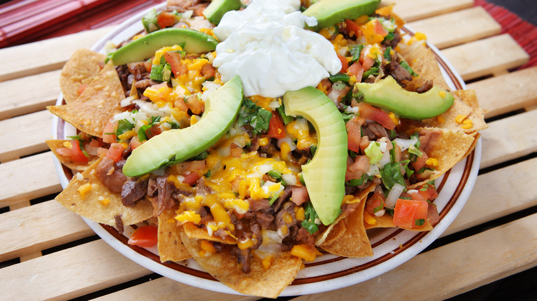 plate of nachos with avocado