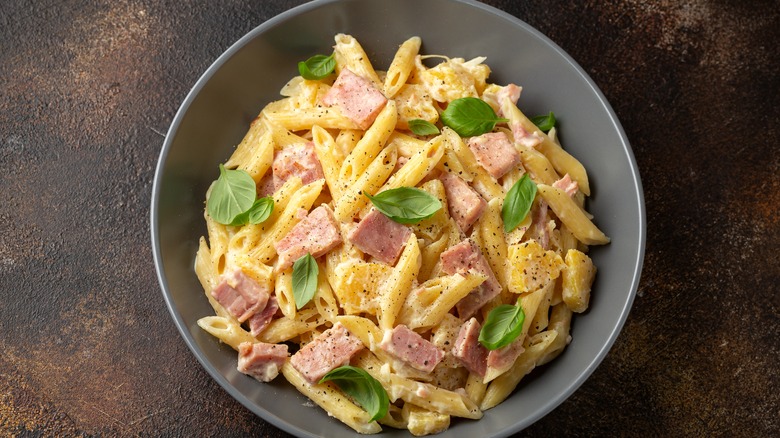 pasta with ham and basil leaves