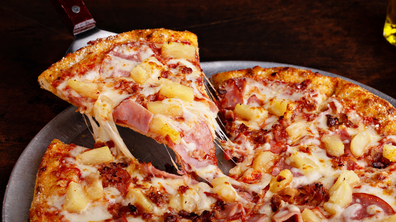 Hawaiian pizza with cut slice