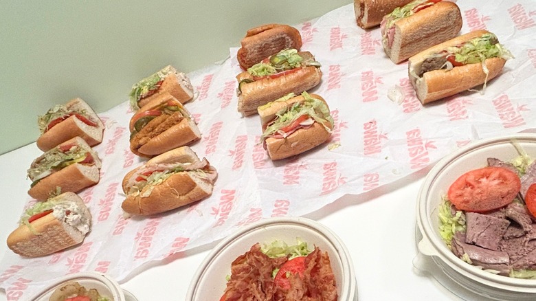 Several hoagies and no-bun hoagies from Wawa against a green and white background