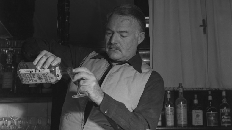 Photo of Ernest Hemingway pouring a drink