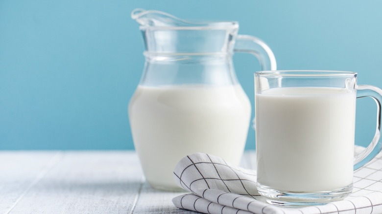 Pitcher and glass of milk, blue background