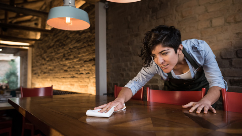 woman wiping table
